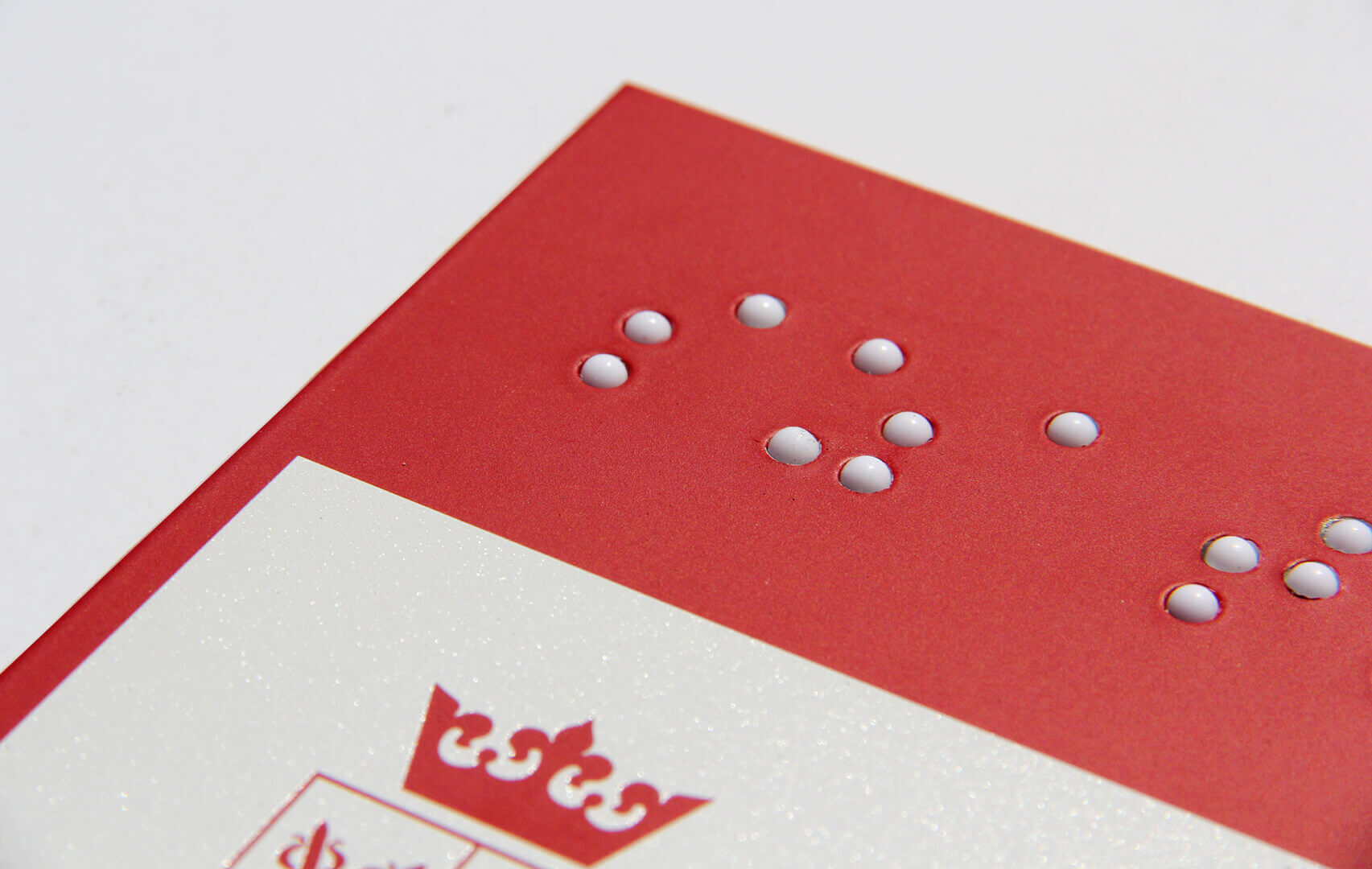Informationstafel - Braille-Zeichen für Blinde in weiß und rot.